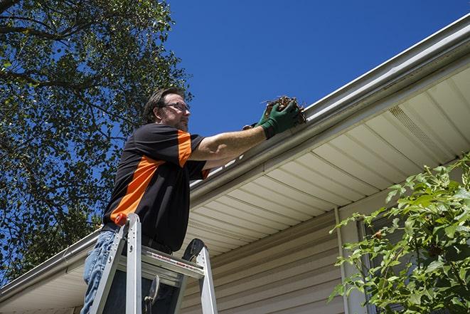 a gutter repair specialist working on a broken downspout in Allen Park